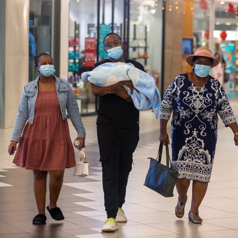 People with masks walk at a shopping mall in Johan