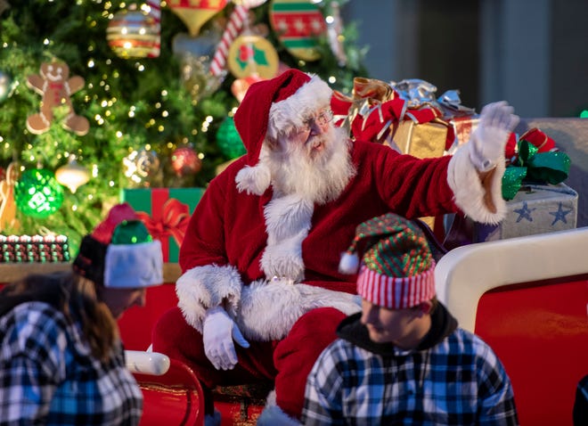 Santa waves to kids during Winterfest Pensacola in Downtown Pensacola Saturday, November 27, 2021. Winterfest Pensacola includes trolley tours, music, photos with Santa and the Grinch and much more.