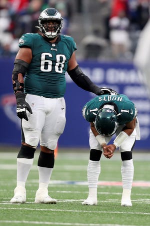 Philadelphia Eagles offensive tackle Jordan Mailata, left, stands with quarterback Jalen Hurts after a pass intended for wide receiver Jalen Reagor was broken up in the fourth quarter of an NFL football game against the New York Giants, Sunday, Nov. 28, 2021, in East Rutherford, N.J. (Monica Herndon/The Philadelphia Inquirer via AP)