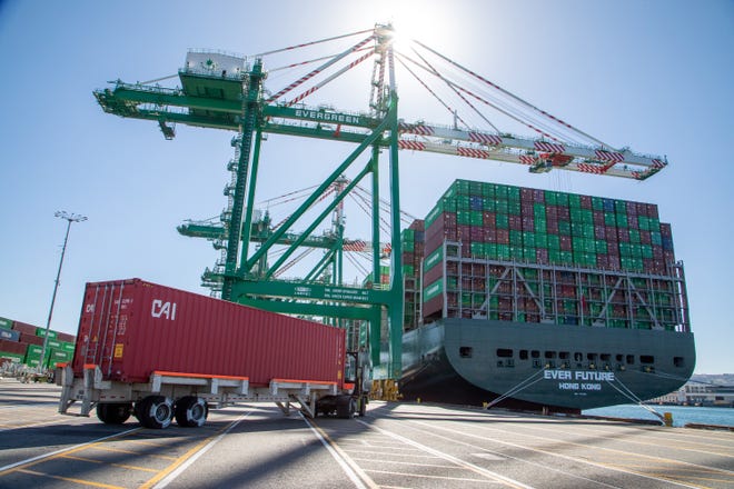 Workers load and unload containers Wednesday, Oct. 13, 2021, at the Evergreen terminal in the Port of Los Angeles. (Chuck Bennett/TNS)