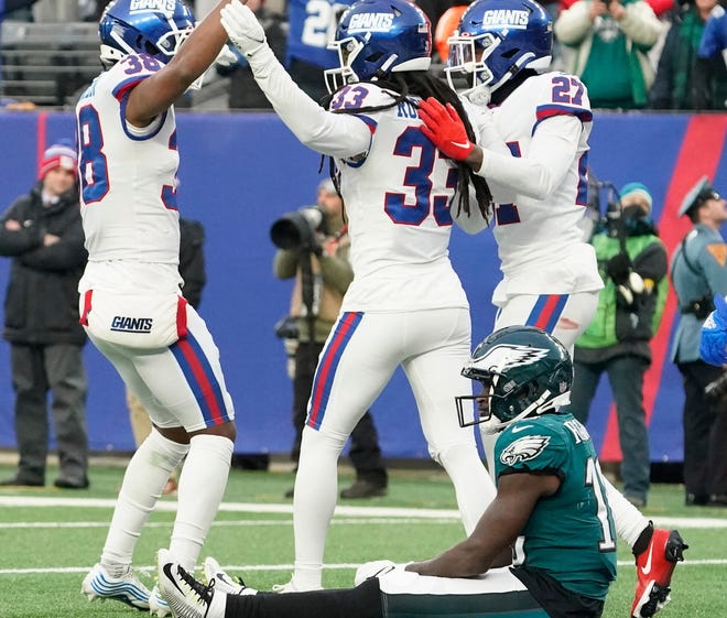 New York Giants defenders celebrate as Philadelphia Eagles wide receiver Jalen Reagor, bottom, reacts after dropping a potential game-winning touchdown with seconds left in the game.