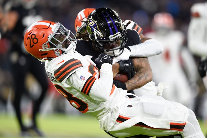 Baltimore Ravens running back Devonta Freeman, center, is tackled by Cleveland Browns outside linebacker Jeremiah Owusu-Koramoah (28), and defensive back Grant Delpit during the first half of an NFL football game, Sunday, Nov. 28, 2021, in Baltimore. (AP Photo/Gail Burton)