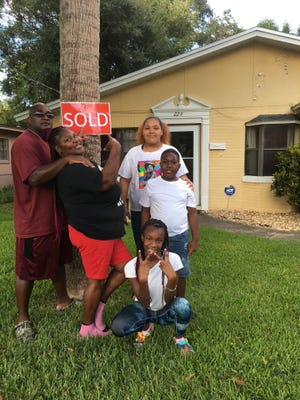 George and Eugena Green, with their children Veronica, Patrice and Jakari, in front of their new home.