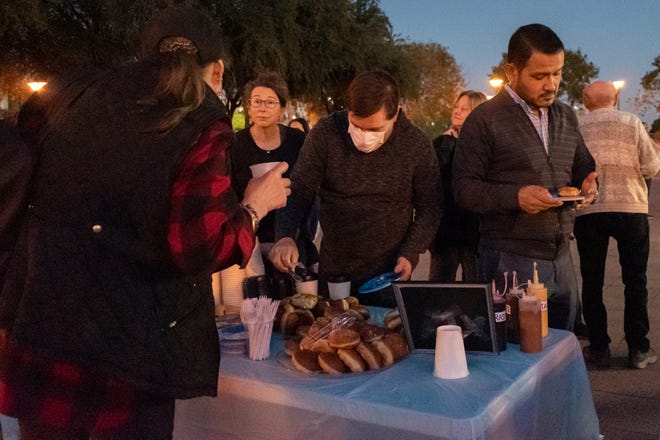 A crowd gathers to eat donuts and drink hot cocoa to celebrate the first night of Chanukah on Nov.  28, 2021, in Phoenix.