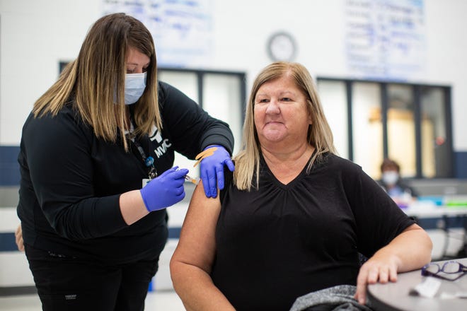 Taylor Hannum, MVHC Urgent Care Manager provides the COVID-19 booster vaccine to Jodi Neff at a vaccine clinic Nov. 12 at Cambridge High School.