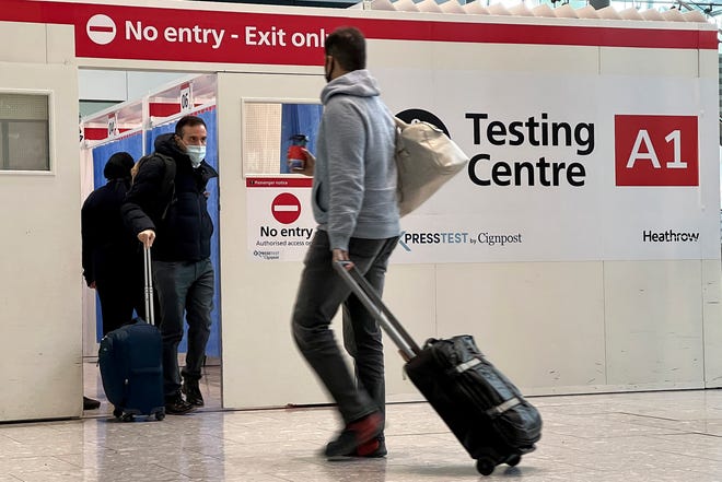 Passengers get a COVID-19 test at a testing center at Heathrow Airport in London on Monday, Nov. 29, 2021.