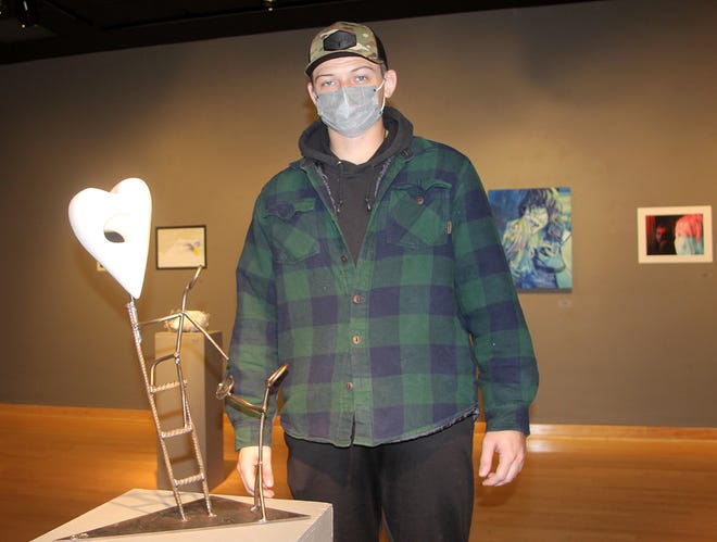 Connor Dickenson '22 of Chatham, Illinois, poses with his sculpture, which was awarded Best of Show at the annual Juried Student Art Exhibition at Monmouth College.