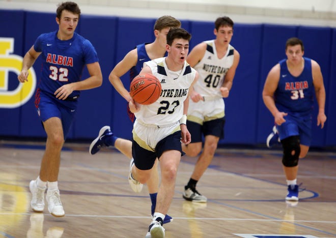 Notre Dame High School's Jackson Brent (23) takes the ball down the court during their game against Albia High School Monday Nov. 29, 2021 at Notre Dame's Father Minett Gymnasium. 