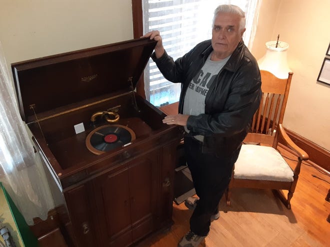 Former Village of Maybee President Len Gaylor stands next to a stand-up phonograph from 1925 that still plays 78 albums with a crank on the side. The antique is one of hundreds of items that will be on display during an open house at the Maybee Historical Museum Saturday.