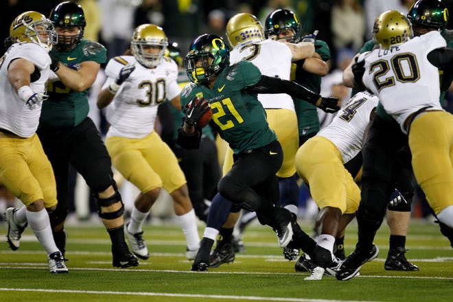 Oregon's LaMichael James breaks through the UCLA line on his way to a first quarter touchdown on the first drive for the Ducks.