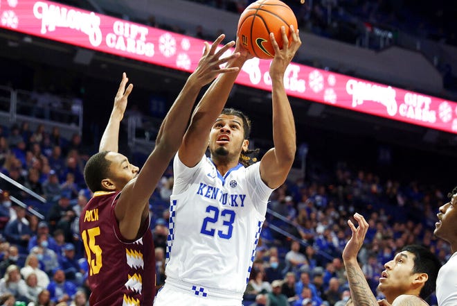 Kentucky's Bryce Hopkins (23) shoots between Central Michigan's Aundre Polk (15) and Oscar Lopez Jr., right, during the first half of Monday's college basketball game in Lexington, Ky.
