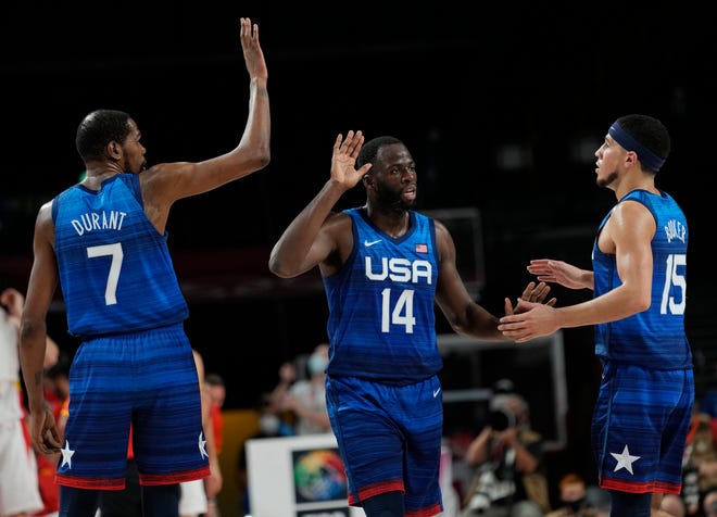 United States' Kevin Durant (7), left, and teammates Draymond Green (14) and Devin Booker (15) celebrate after scoring during men's basketball quarterfinal game at the 2020 Summer Olympics, Tuesday, Aug. 3, 2021, in Saitama, Japan. (AP Photo/Eric Gay).