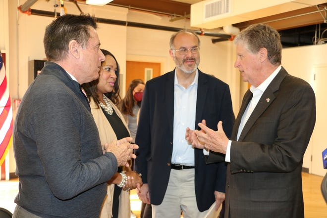 From left, Tommy Sheehan, president of the Hi-Lo Neighborhood Association; Newport Housing Authority Executive Director Rhonda Mitchell; Secretary of Commerce Stefan Pryor; and Gov. Dan McKee chat before a press conference Tuesday in Newport to announce a series of broadband grants.
