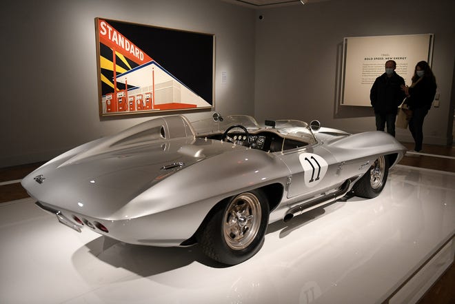 From left, Christopher Maskill, 23, of Romeo and Anais Thiry, 24, visiting from Belgium, look at the 1959 Corvette Stingray Racer in the Detroit Style: Car Design in the Motor City, 1950-2020 exhibit at the Detroit Institute of Arts in Detroit on Dec. 1, 2021.   The DIA is one of 11 cultural institutions that will benefit from a new arts and cultural initiative and endowment from the Ralph C. Wilson Jr. Foundation.