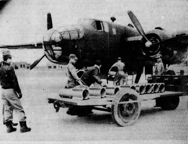 A crew loads a bomber plane with parachute flares to test them on the Jefferson Proving Ground in March 1943.