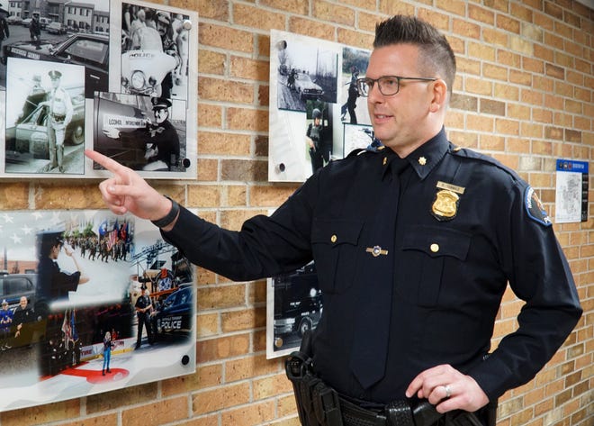                                Retiring Northville Township Chief of Police Paul Tennies points to a photo of the township's first officer - who was hired mostly as its dog catcher.