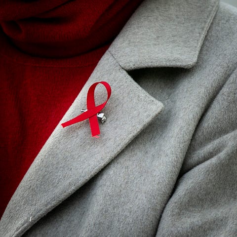 A red ribbon is seen on the lapel of Ann Ricketts,