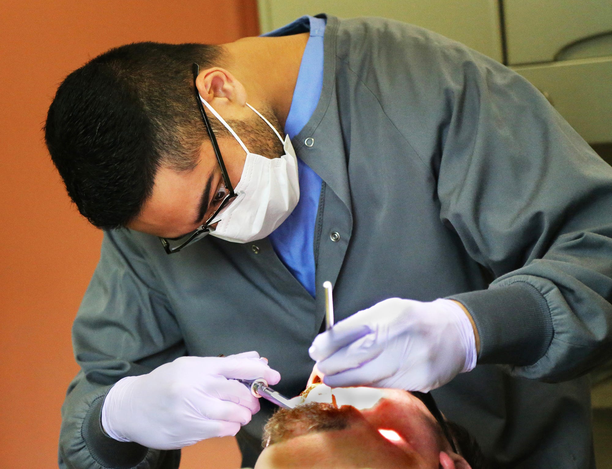 Tufts dental student Aziz Pradhan extracts 3 teeth from Curtis Cole's mouth which were causing him excruciating pain for 8 months. He finally was able to be seen by dental at Goodwin Community Health in Somersworth Sept. 8, 2021.