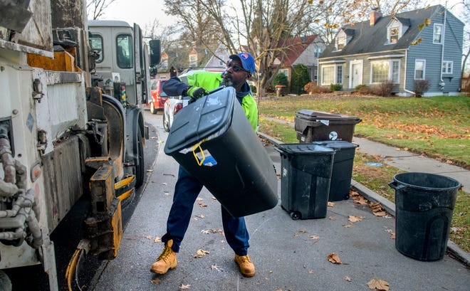 GFL Environmental garbage collector Gerald Cummings dumps a can into his truck Thursday, Dec. 2, 2021 on his route through Peoria.