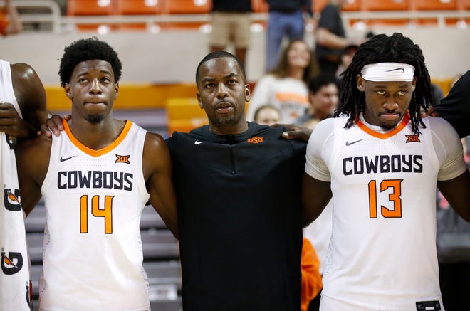 Oklahoma State head coach Mike Boynton stands with Bryce Williams, left, and Isaac Likekele after losing to Wichita State on Dec. 1 in Stillwater, Okla. The Cowboys are in a rough stretch of scheduling, having to face Houston, Kansas and now Texas.