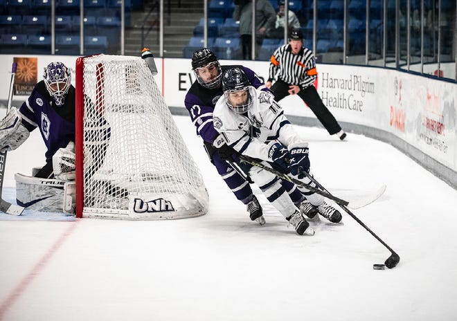 UNH's Jackson Pierson brings the puck around the net during last Saturday's 3-2 overtime win over Holy Cross.