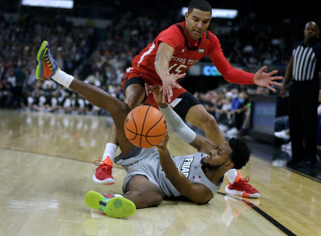 Providence guard Al Durham tries to shuffle off the ball after slipping and hitting the floor while playing against Texas Tech's Kevin McCullar in the first half of a Big 12-Big East Battle contest Wednesday at the Dunkin Donuts Center in Providence, Rhode Island.