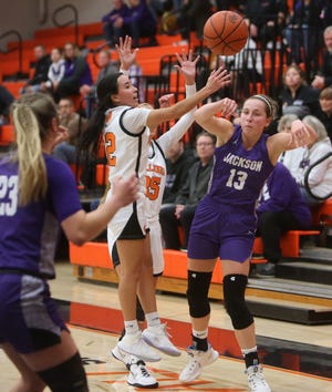 Emma Dretke (13) of Jackson passes to Lauren Pallotta (23) while being defended by Brianna Hunt (center) of Green during their game at Green on Wednesday.