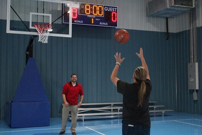 La comisionada de la ciudad de Panamá, Jenna Flint Haligas, y el entrenador deportivo de élite del sur, Joe Garner, juegan baloncesto en la recién renovada AD Harris High School,