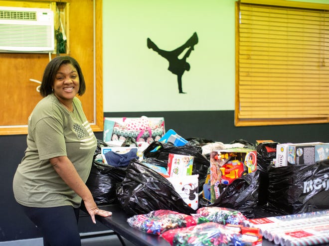 Quiana Revere showcases the unwrapped Christmas presents her staff team picked out for the families DiverseMoves adopted this holiday season.