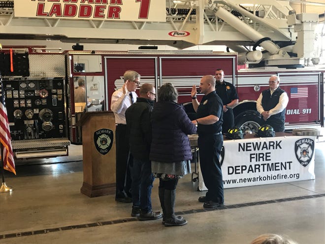 Brandon Bynorth (right) is sworn in by Newark Safety Director Tim Hickman (left) as one of Newark's newest firefighters during a ceremony at Newark Fire Station 1 on Monday, Nov. 29, 2021 as Bynorth's parents, Gordon and Lainie Bynorth, look on.