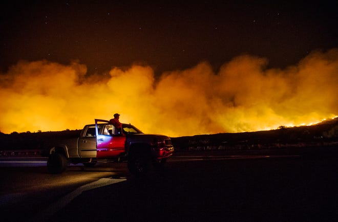 Lindsey Black from Queen Creek, Arizona, watches the Telegraph Fire burn in the Tonto National Forest near Superior, Arizona, on June 5, 2021. She was stuck in traffic on the U.S. 60.