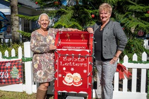 Jeanette and Linda Bokland stand next to their new mail box for their “Letters to Santa” project at their home in Mount Dora.