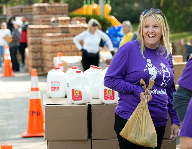 Kelli Marks, founder of the nonprofit Backpack Buddies of Orange City, helps with the organization's drive-thru food pantry in Orange City, Friday, Dec. 3, 2021.