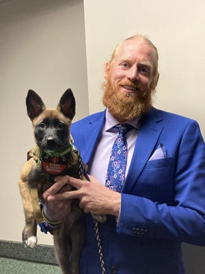 Joshua Rohrer outside court on Thursday, Dec. 2, 2021, with his new service dog Justice Rae.