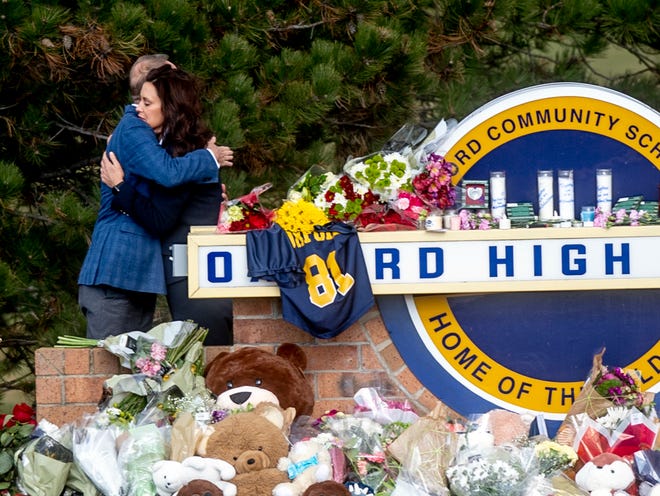 Gov. Gretchen Whitmer embraces Oakland County Executive Dave Coulter as the two leave flowers and pay their respects Thursday morning, Dec. 2, 2021 at Oxford High School in Oxford, Mich. A 15-year-old boy has been denied bail and moved to jail after being charged in the Michigan school shooting that killed four students and injured others.(Jake May/The Flint Journal via AP)