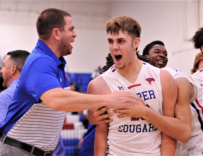 Cooper's Tristen Rau, right, celebrates with coach Bryan Conover and his teammates after scoring the game-winning basket in the Cougars' 52-51 victory over Keller Timber Creek in the opening round of the Raising Cane's Key City Classic on Thursday, Dec. 2, 2021, at Cougar Gym.