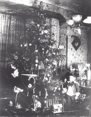 Walter and Robert Hueck in front of an early Christmas tree at Christmas Hueck's Opera House upstairs apartment in Over-The-Rhine, 1895.
