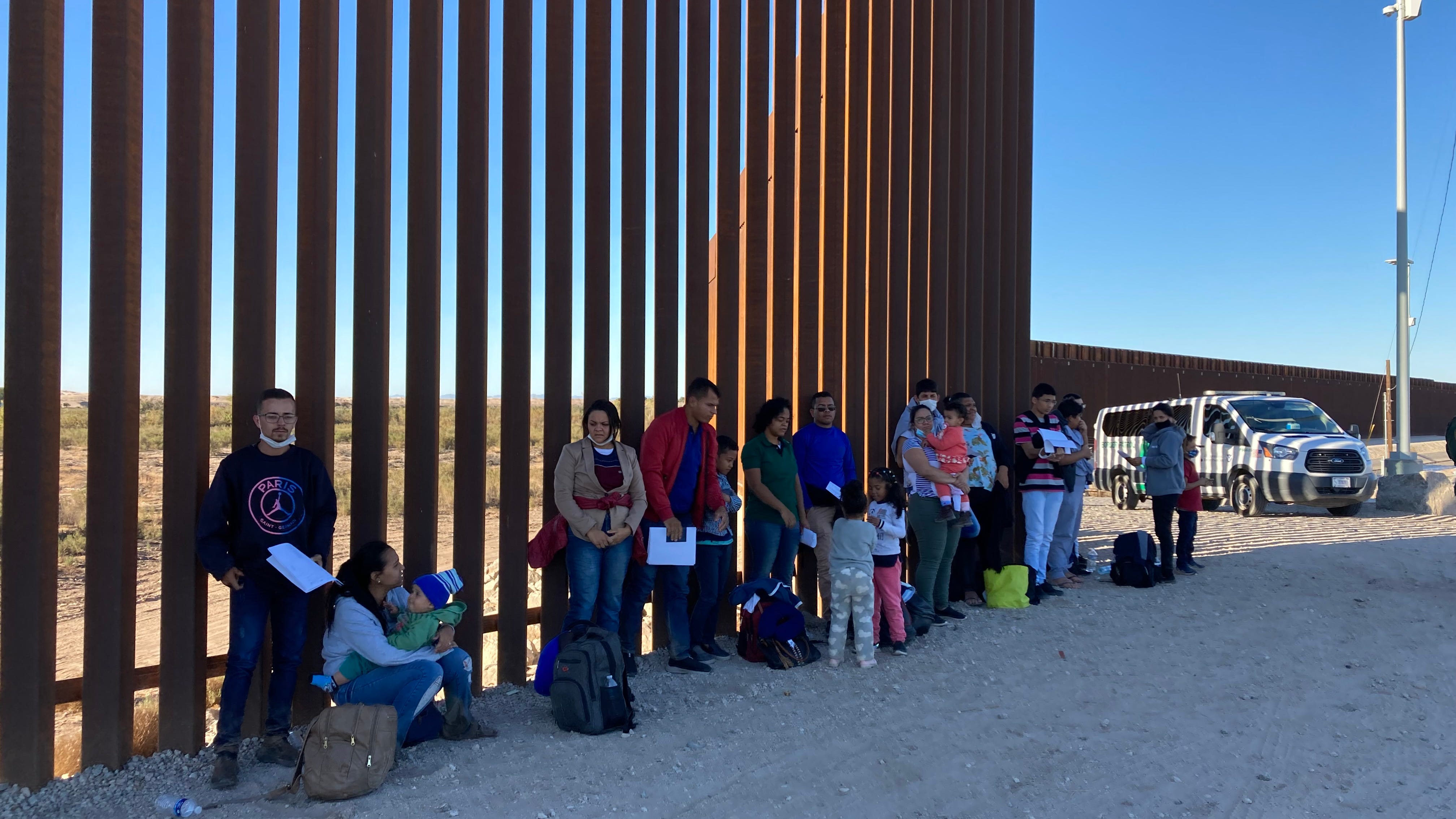 Families and single adults wait with their papers in hand to be processed by Border Patrol agents. The group of about 30 people crossed the U.S.-Mexico border illegally near Somerton, Arizona, on Monday, Nov. 29, 2021.