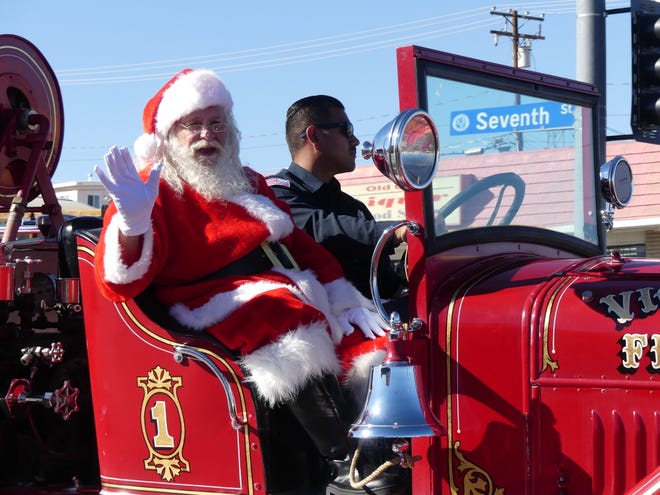 Santa Claus rides on a vintage fire engine Saturday during the 74th Annual Victorville Christmas Parade.