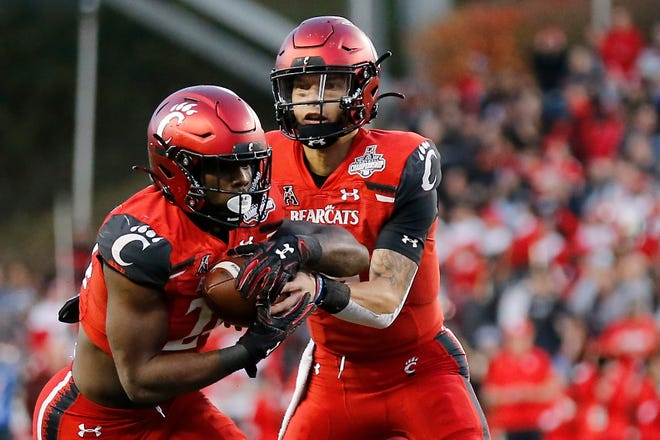 Cincinnati Bearcats quarterback Desmond Ridder (9) hands off to running back Jerome Ford (24) in the second quarter of the American Athletic Conference Championship football game between the Cincinnati Bearcats and the Houston Cougars at Nippert Stadium in Cincinnati on Saturday, Dec. 4, 2021. The Bearcats led 14-13 at the half.