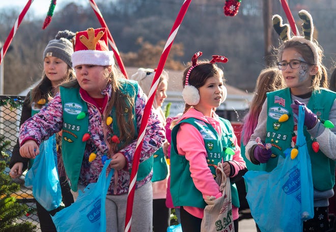 Members of Girl Scout Troop 46725 toss out candy during Monaca's Christmas Parade Saturday.
