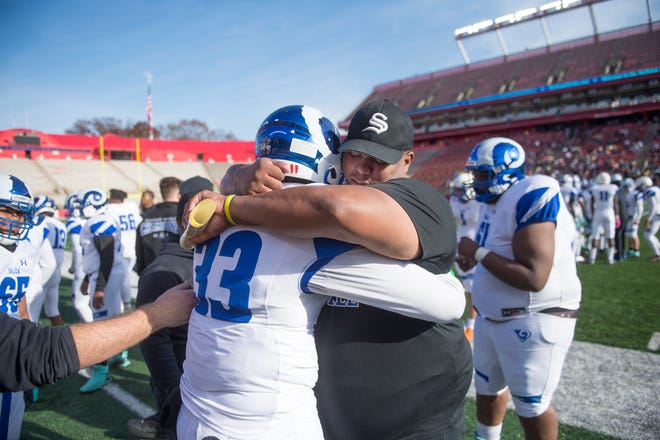 Salem High School football coach Montrey Wright hugs Salem's Jasir Thompson
after Salem defeated Woodbury, 34-8, in the South-Central Group 1 regional championship football game played at Rutgers University in Piscataway on Sunday, December 5, 2021.