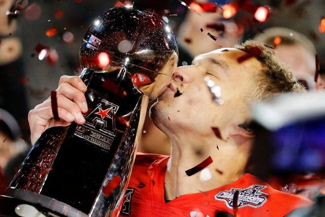 Cincinnati Bearcats senior quarterback Desmond Ridder kisses the American Athletic Conference championship trophy. A Louisville native, Ridder is the nation's winningest college quarterback with a career record of 41-5.