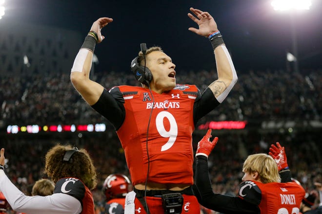 Cincinnati Bearcats quarterback Desmond Ridder (9) pumps up the crowd behind the bench in the fourth quarter of the American Athletic Conference Championship football game between the Cincinnati Bearcats and the Houston Cougars at Nippert Stadium in Cincinnati on Saturday, Dec. 4, 2021. The Bearcats remained unbeaten as they won the AAC Championship with a 35-20.