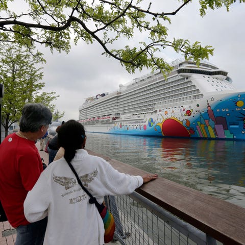 FILE - People pause to look at Norwegian Cruise Li