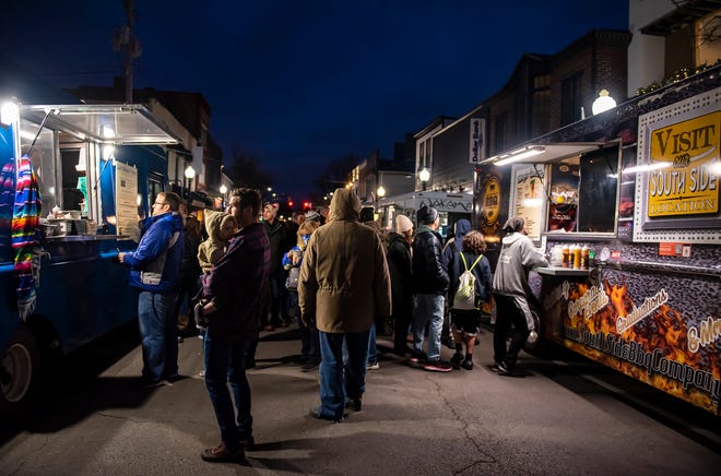 Visitors to Sewickley's Light Up Night in Sewickley wait in line to buy from the food trucks lined up along Beaver Street Friday evening.