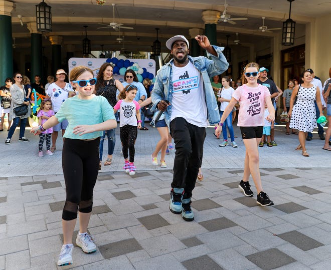 Sean Green, center, a South Florida Instagram and TikTok dance star, leads a family-friendly dance session at Rosemary Square in West Palm Beach in early December.