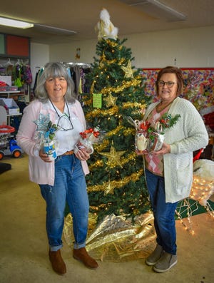 Truth Resale Store co-managers Linda Wamsley, left, and Trish Hogan hold some of the handmade Christmas mugs for sale at their store. The shop is filled with Christmas items.