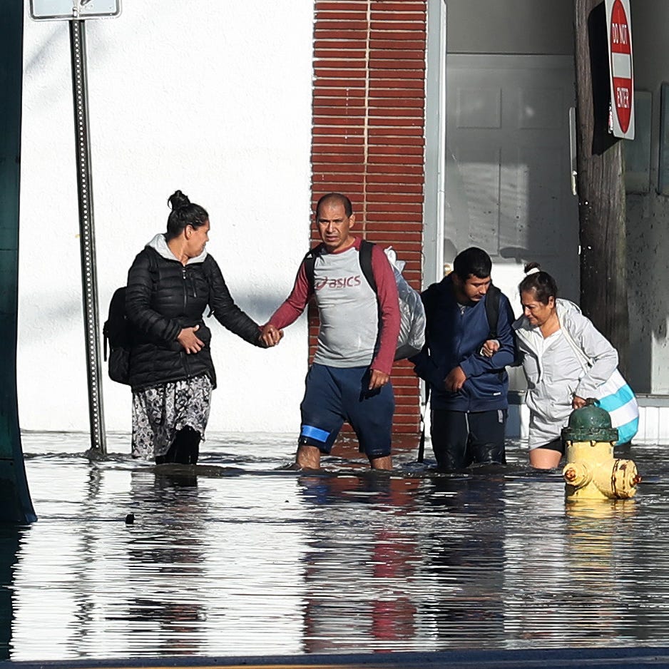 A family wades in the water as they evacuate their home along Mamaroneck Avenue in Mamaroneck Sept. 2, 2021. Rains from Ida flooded the area overnight.