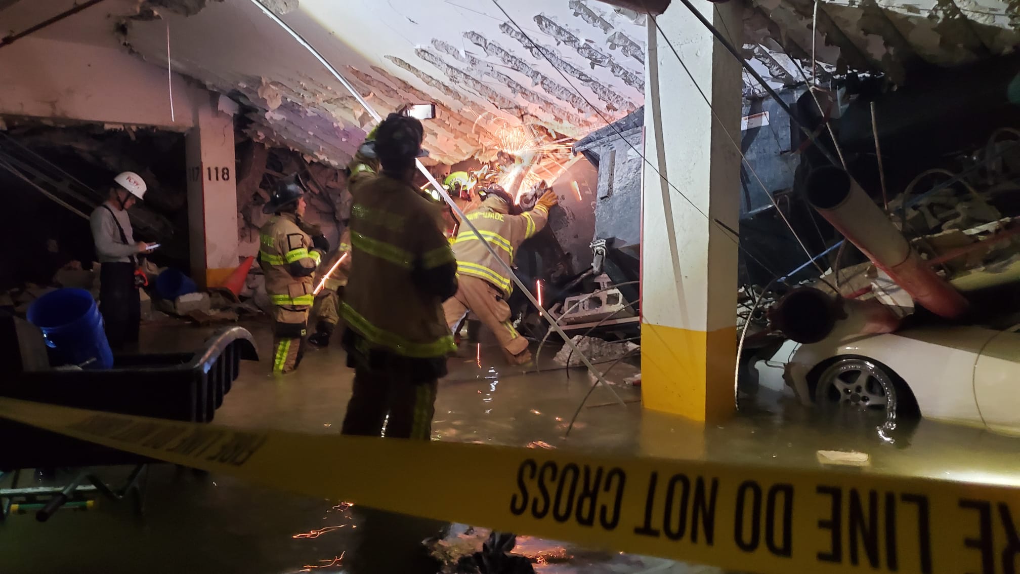 First responders in the underground garage of Champlain Towers South work to free a trapped victim on June 24, 2021.